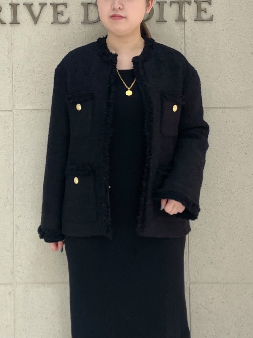 ブラック系のその他アウター、ブラック系のワンピース、ブラック系のハンドバッグを着用したレディースの冬コーディネートの5枚目の写真