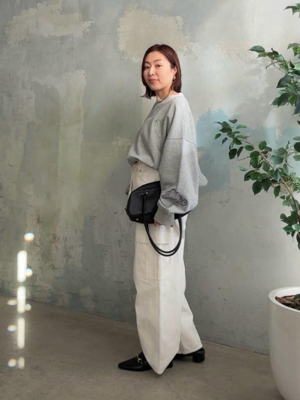 グレー系のTシャツ/カットソー、ホワイト系のカーゴパンツ、ブラック系のパンプスを着用したレディースの冬コーディネートの2枚目の写真