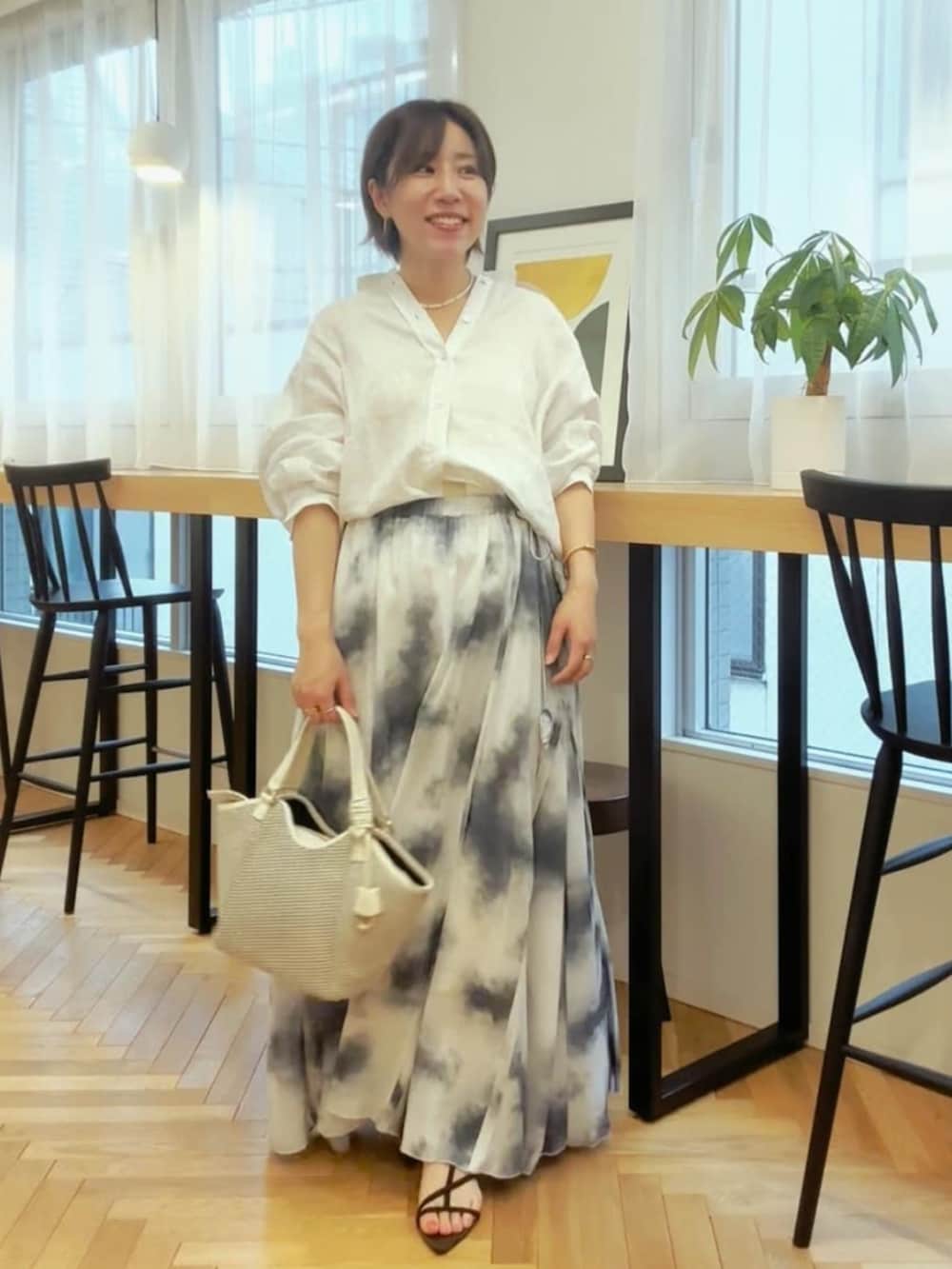 ホワイト系のシャツ/ブラウス、ブラック系のサンダル、ホワイト系のハンドバッグを着用したレディースの春コーディネートの3枚目の写真