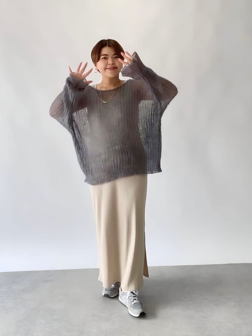 ベージュ系のワンピース、ホワイト系のニット/セーターを着用したレディースの秋コーディネートの3枚目の写真