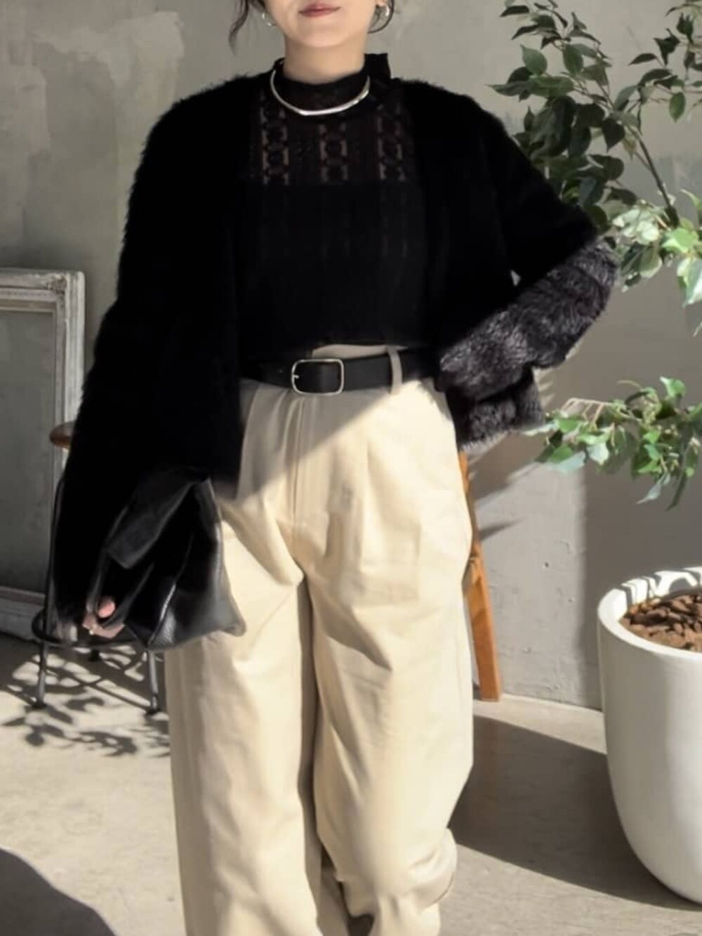 ブラック系のTシャツ/カットソー、ブラック系のトートバッグ、シルバー系のネックレスを着用したレディースの冬コーディネートの3枚目の写真