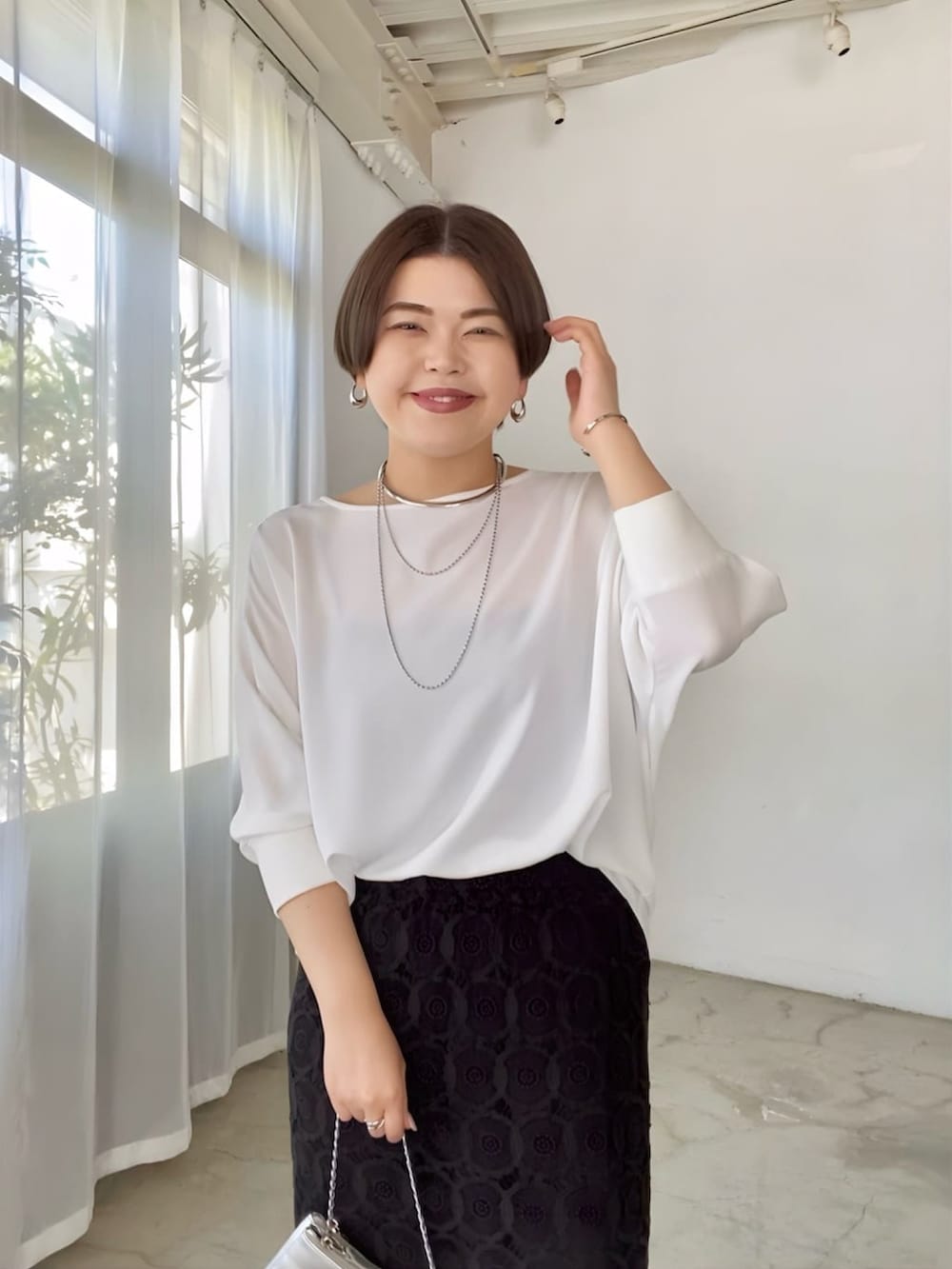 ホワイト系のシャツ/ブラウス、ブラック系のスカート、ブラック系のサンダルを着用したレディースの夏コーディネートの4枚目の写真