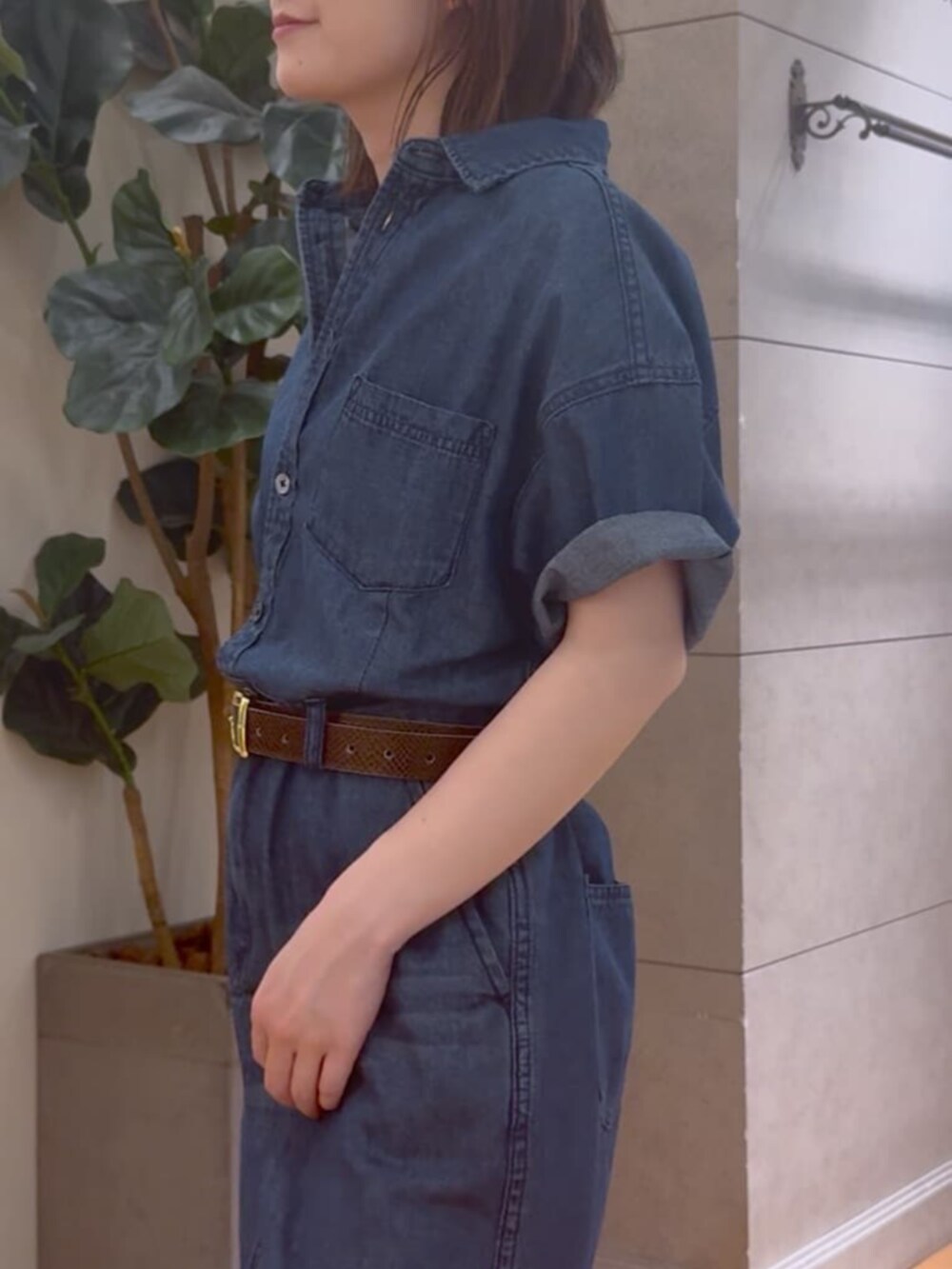 ブラック系のハンドバッグ、ブルー系のワンピース、ゴールド系のネックレスを着用したレディースの夏コーディネートの5枚目の写真