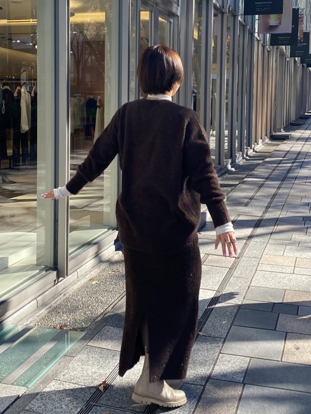 ベージュ系のその他アウター、ブラウン系のカーディガン/ボレロ、ブラウン系のスカートを着用したレディースの冬コーディネートの5枚目の写真