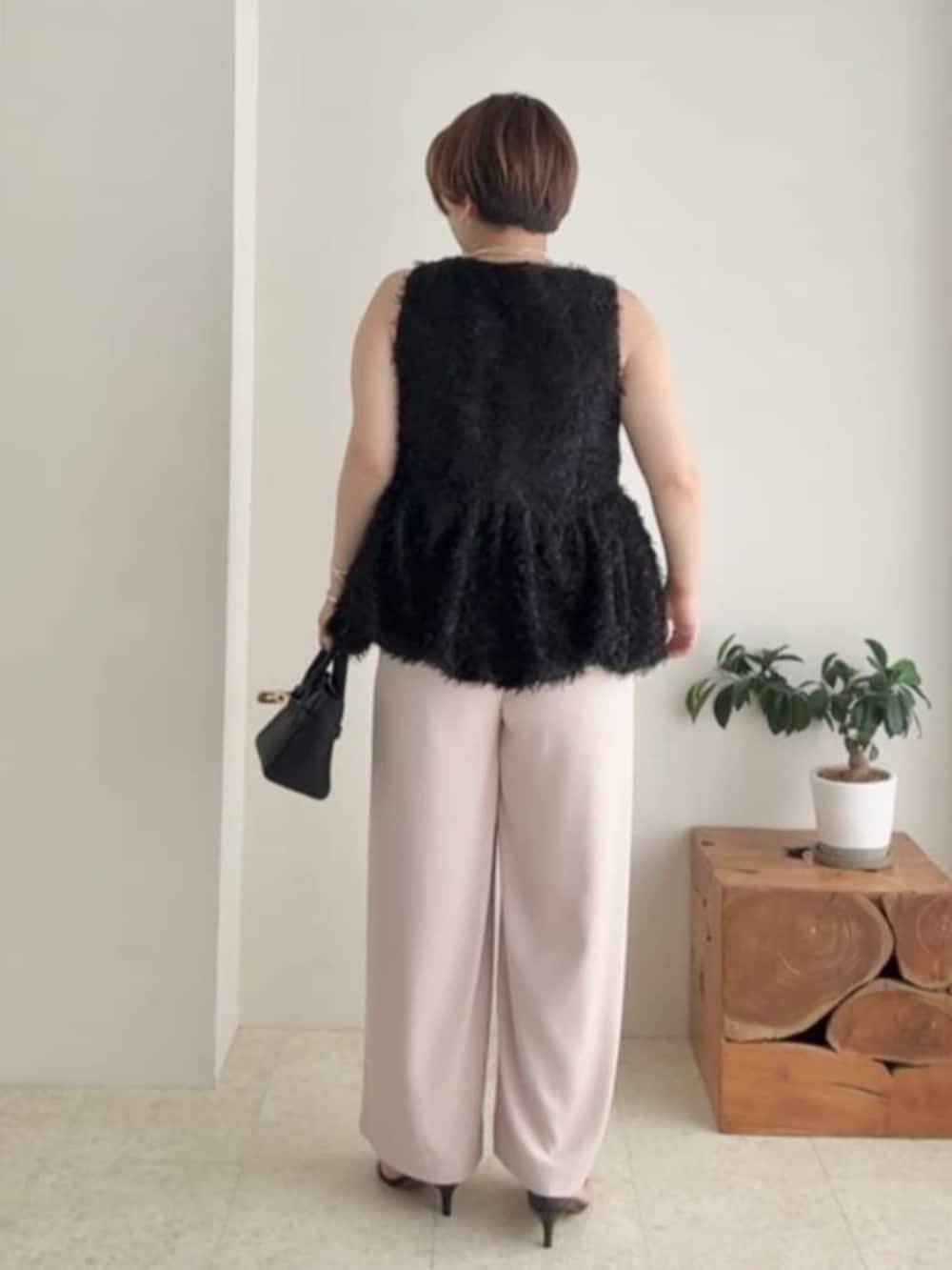 ピンク系のスラックス、ブラック系のトートバッグ、ブラック系のシャツ/ブラウスを着用したレディースの夏コーディネートの2枚目の写真