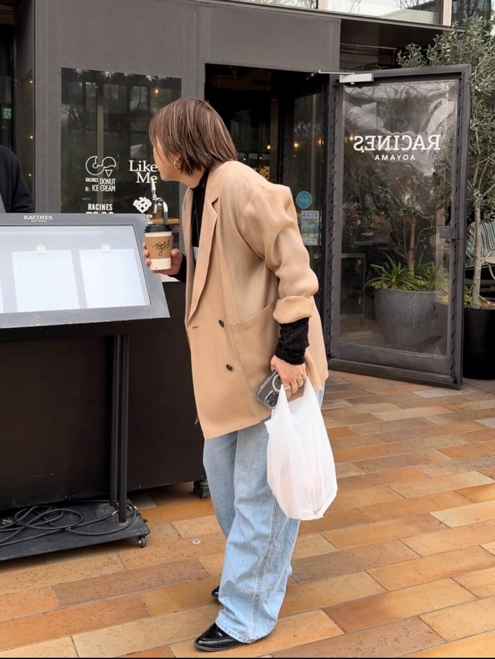 ブラック系のテーラードジャケット、ブルー系のサロペット/オーバーオール、ブラック系のTシャツ/カットソーを着用したレディースの春コーディネートの2枚目の写真