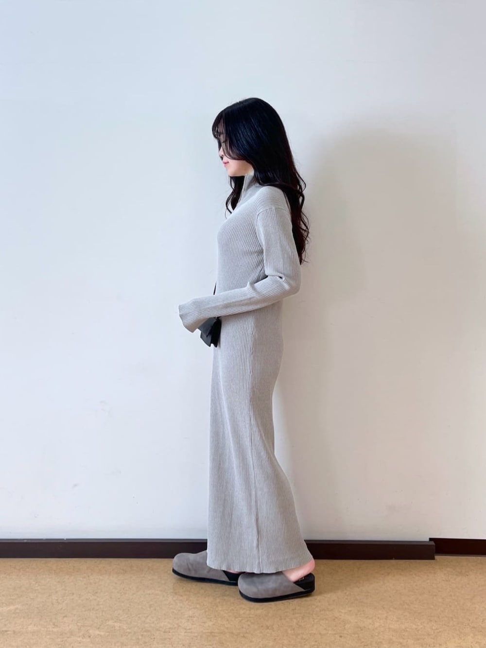 ブラック系のマウンテンパーカー、グレー系のワンピース、ブラック系のショルダーバッグを着用したレディースの春コーディネートの4枚目の写真