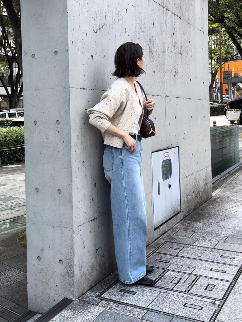 ブルー系のデニムパンツ、ホワイト系のニット/セーター、ブラック系のパンプスを着用したレディースの秋コーディネートの2枚目の写真