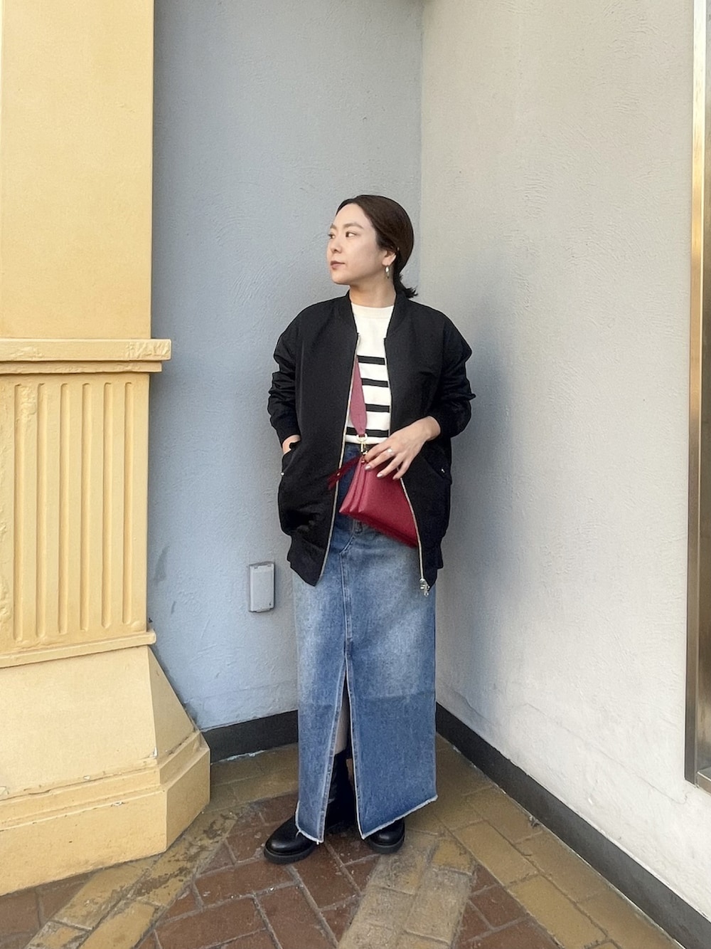 ホワイト系のニット/セーター、ブルー系のデニムスカート、ブラック系のブーツを着用したレディースの秋コーディネートの2枚目の写真