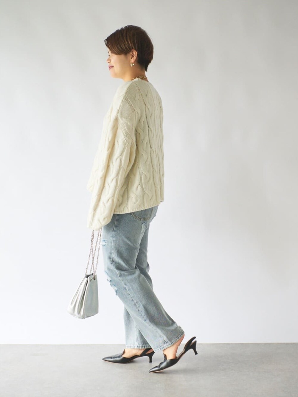 ブラウン系のダウンジャケット/コート、ブルー系のデニムパンツ、ブラウン系のローファーを着用したレディースの秋コーディネートの4枚目の写真