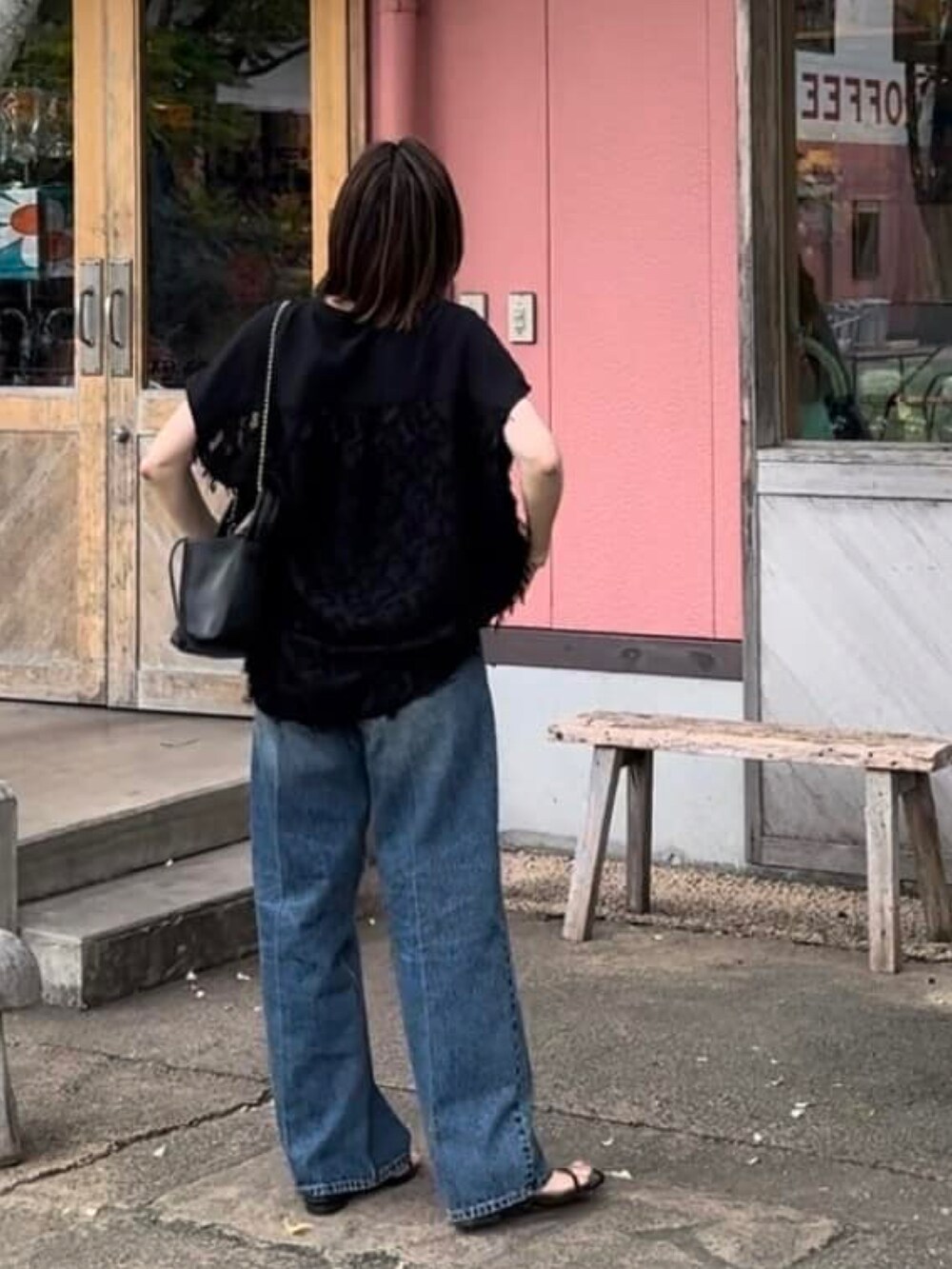 ブラック系のシャツ/ブラウス、ブラック系のサンダル、ブルー系のデニムパンツを着用したレディースの夏コーディネートの3枚目の写真