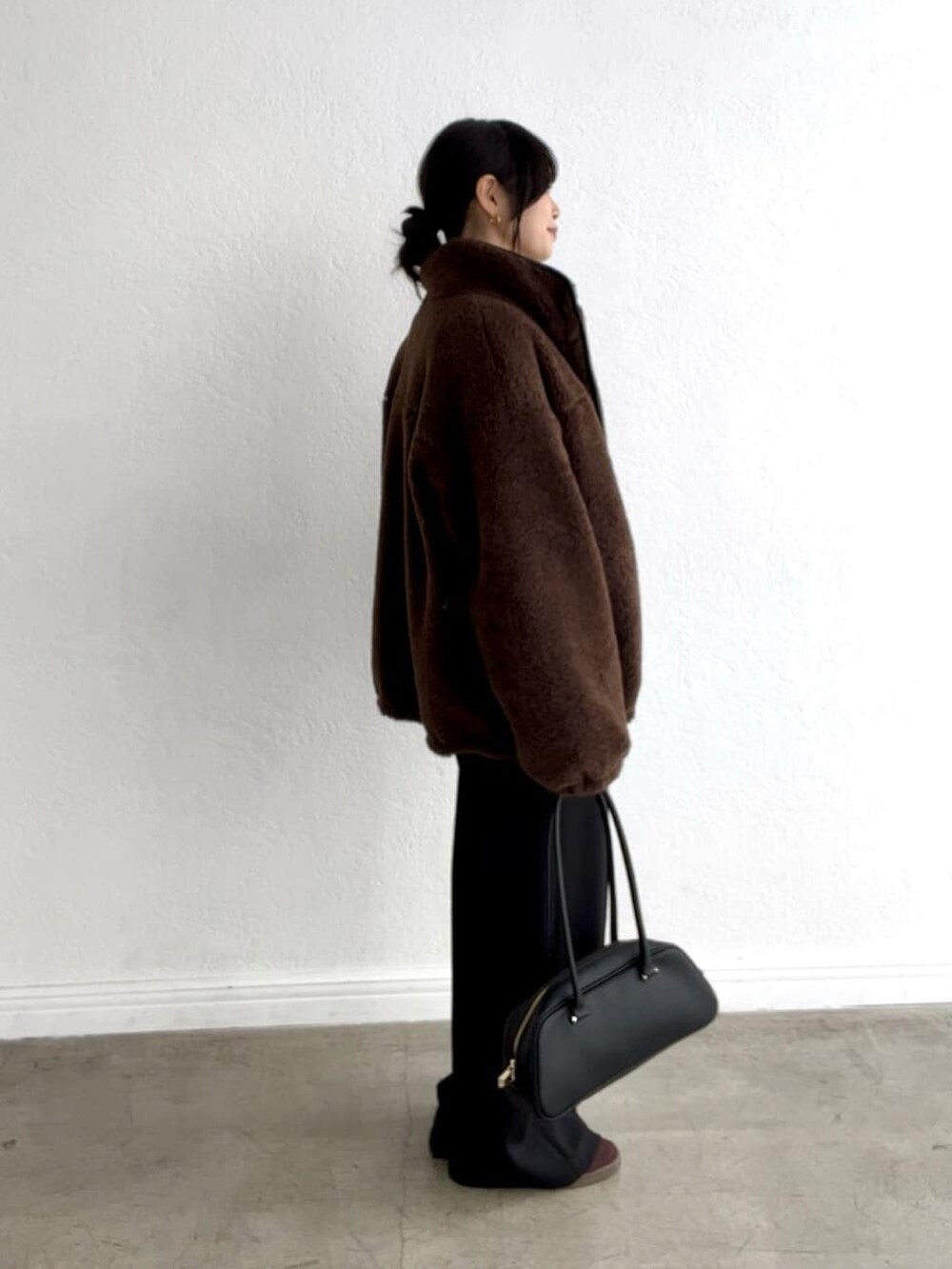 グレー系のニット/セーター、ブラウン系のその他アウター、ブラック系のその他パンツを着用したレディースの秋コーディネートの3枚目の写真