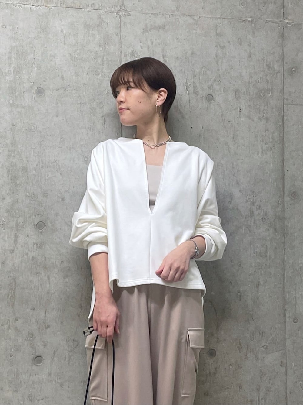 ホワイト系のスウェット、ベージュ系のカーゴパンツ、シルバー系のパンプスを着用したレディースの春コーディネートの4枚目の写真