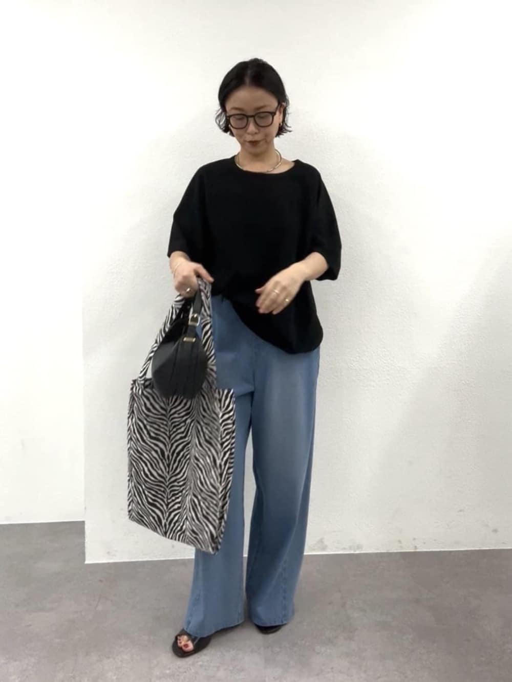 ブラック系のショルダーバッグ、ブラック系のTシャツ/カットソー、ブラック系のトートバッグを着用したレディースの春コーディネートの2枚目の写真