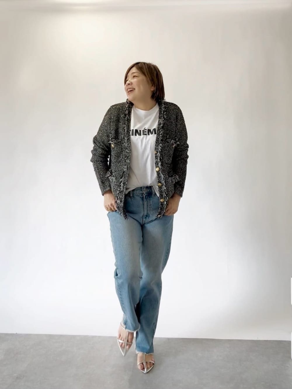 ブルー系のデニムパンツ、ホワイト系のTシャツ/カットソー、ブラック系のカーディガン/ボレロを着用したレディースの冬コーディネートの2枚目の写真