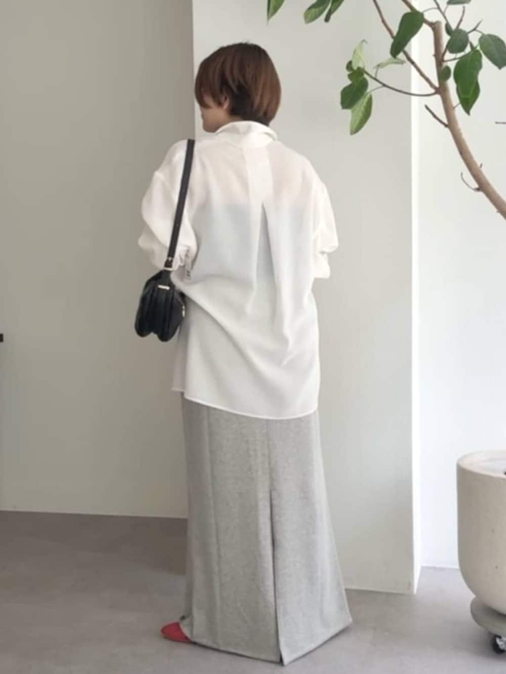 ブラック系のショルダーバッグ、グレー系のスカート、ホワイト系のシャツ/ブラウスを着用したレディースの春コーディネートの3枚目の写真