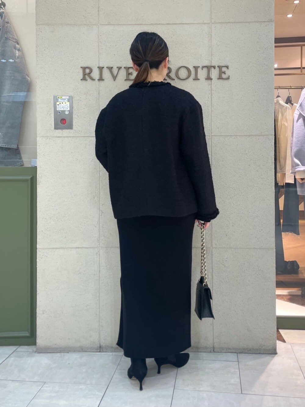 ブラック系のその他アウター、ブラック系のワンピース、ブラック系のハンドバッグを着用したレディースの冬コーディネートの4枚目の写真