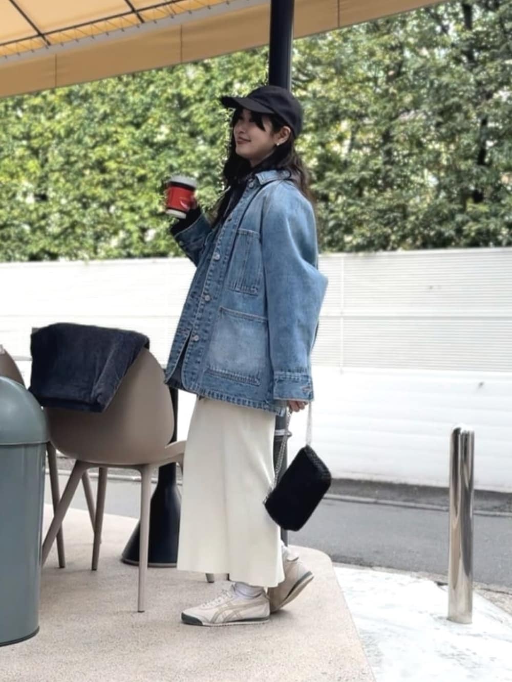 ブルー系のニット/セーター、ブラック系のシャツ/ブラウス、ブルー系のデニムジャケットを着用したレディースの春コーディネートの2枚目の写真