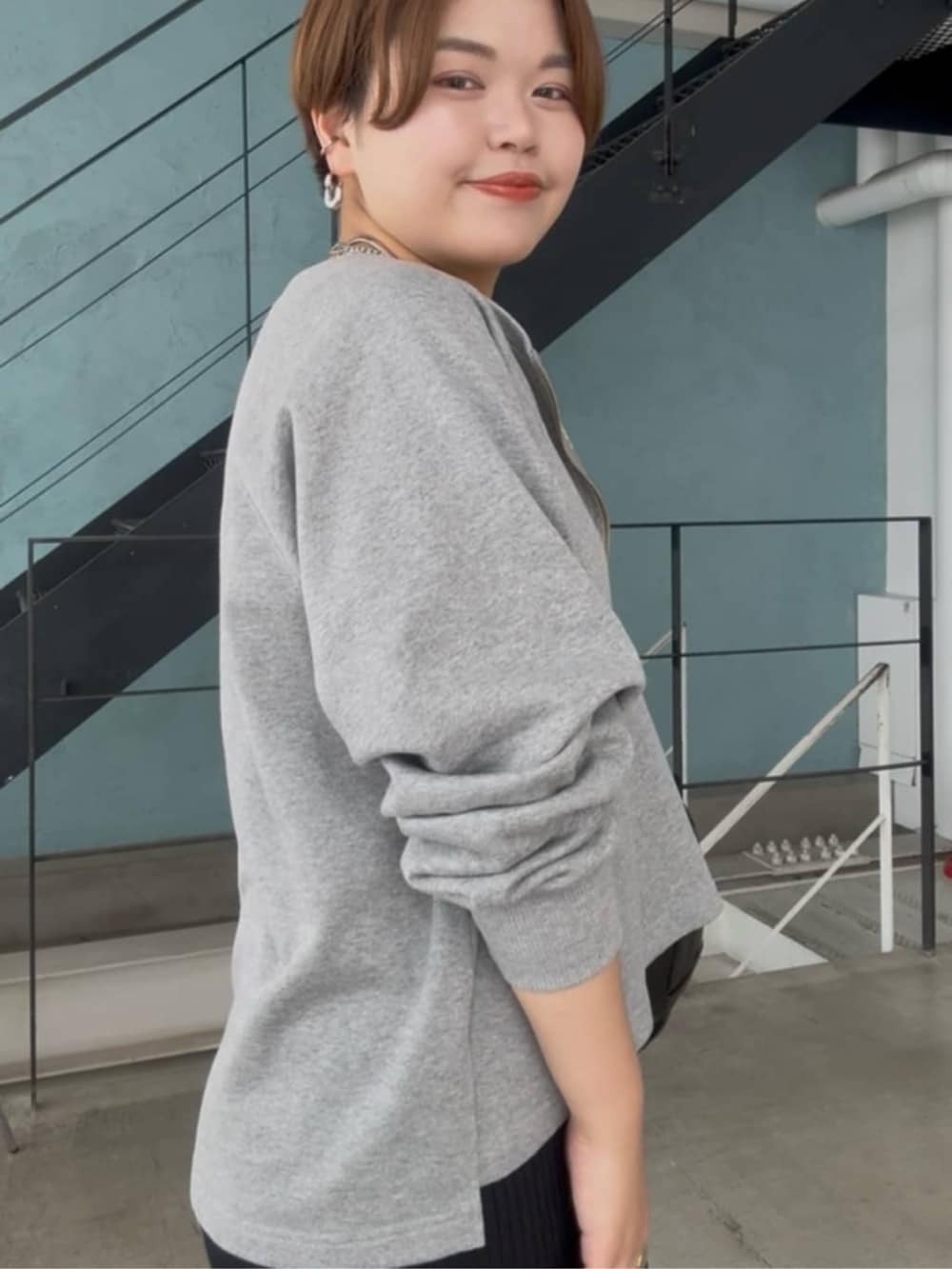 グレー系のスウェット、ブラック系のワンピース、シルバー系のチョーカーを着用したレディースの春コーディネートの6枚目の写真