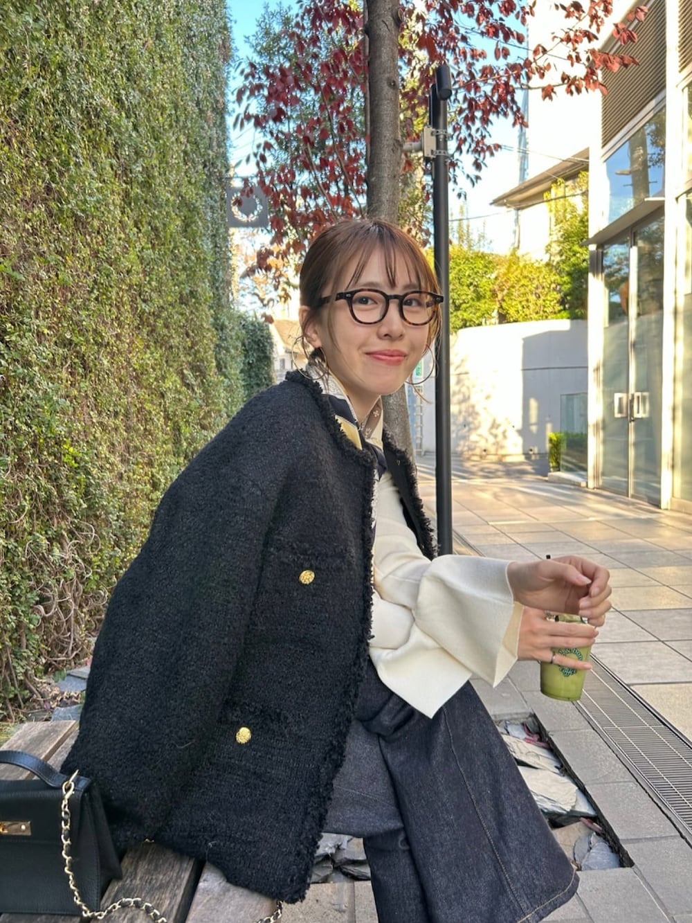 ブラック系のその他アウター、ホワイト系のニット/セーター、ブルー系のデニムパンツを着用したレディースの冬コーディネートの4枚目の写真