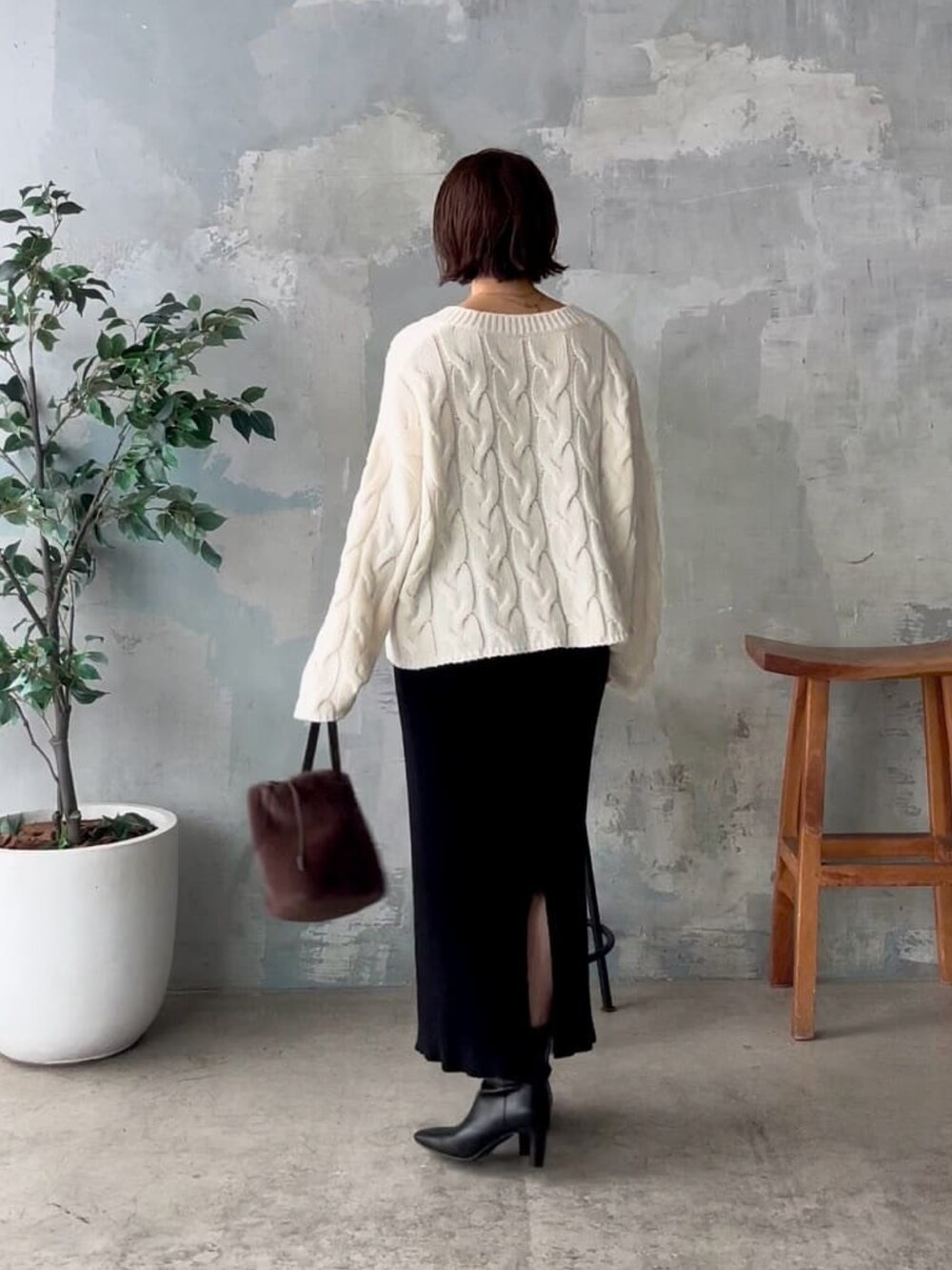 ホワイト系のニット/セーター、ブラック系のスカート、ブラウン系のハンドバッグを着用したレディースの秋コーディネートの3枚目の写真