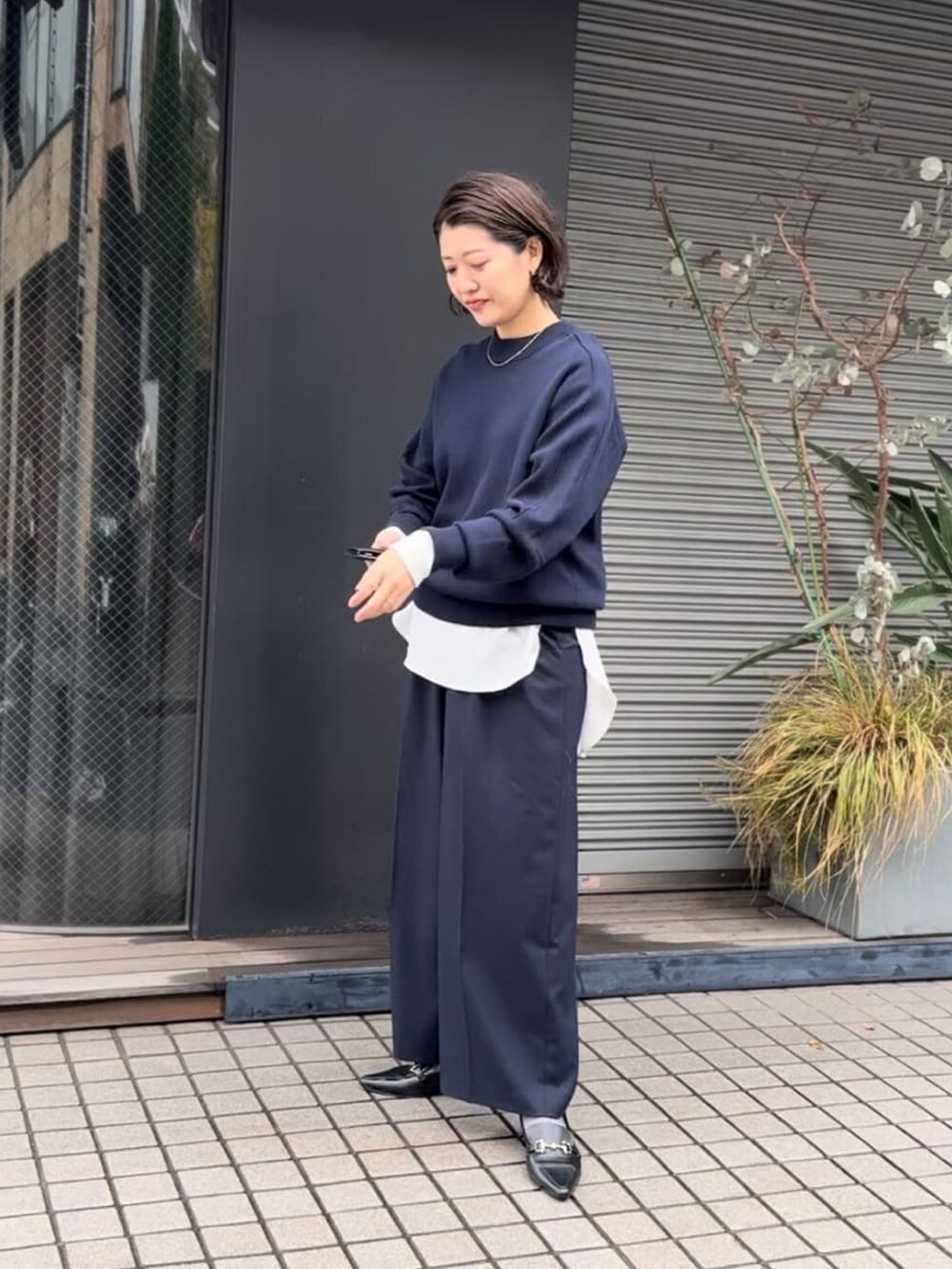 ブルー系のニット/セーター、ブルー系のその他パンツ、ホワイト系のシャツ/ブラウスを着用したレディースの冬コーディネートの2枚目の写真