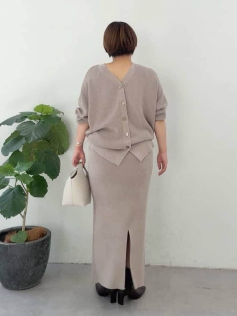 ホワイト系のハンドバッグ、ホワイト系のパーカー、ブラウン系のニット/セーターを着用したレディースの冬コーディネートの5枚目の写真