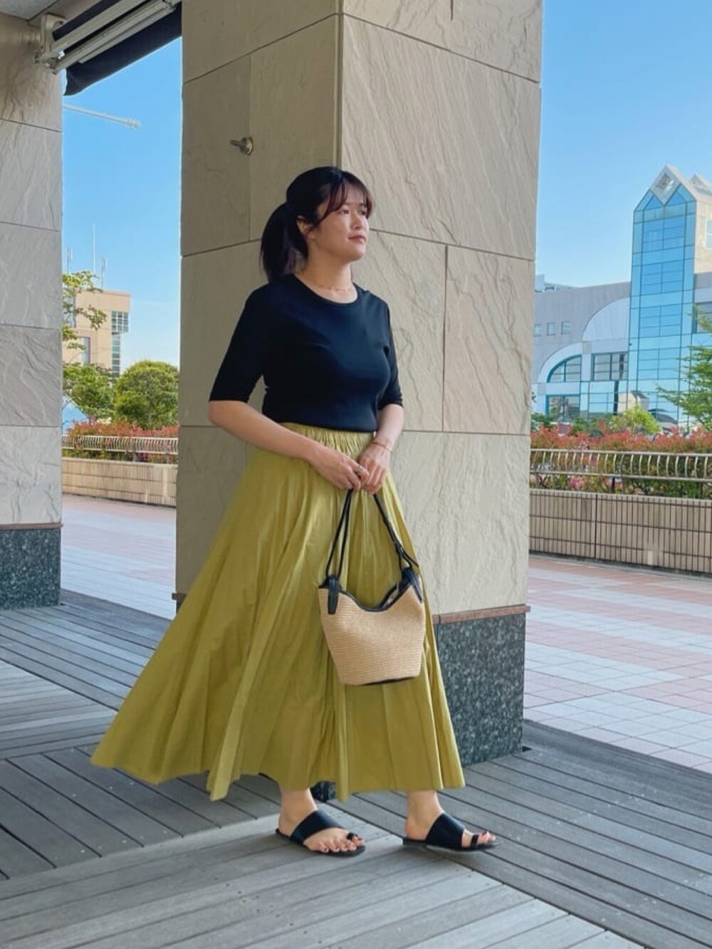 ブラック系のTシャツ/カットソー、グリーン系のスカートを着用したレディースの春コーディネートの2枚目の写真