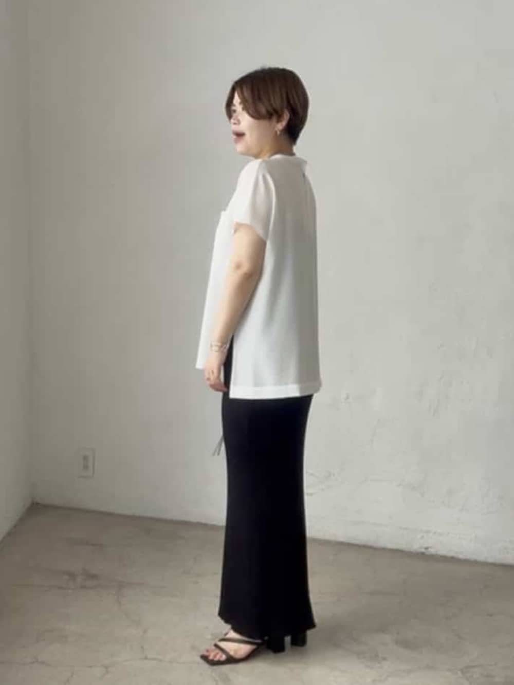 ホワイト系のシャツ/ブラウス、ブラック系のスカート、ブラック系のハンドバッグを着用したレディースの春コーディネートの2枚目の写真