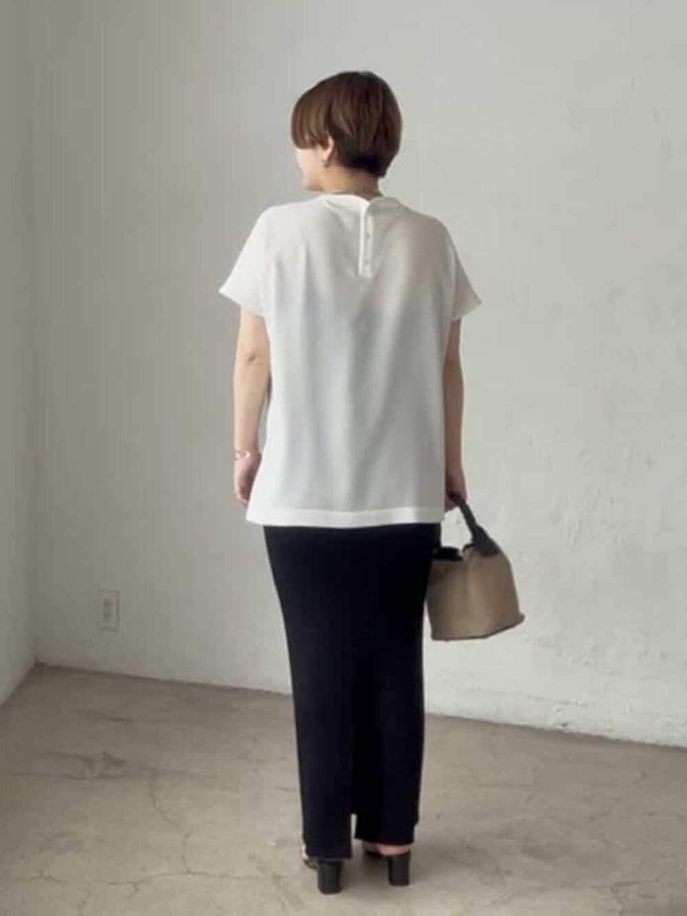 ホワイト系のシャツ/ブラウス、ブラック系のスカート、ブラック系のハンドバッグを着用したレディースの春コーディネートの3枚目の写真