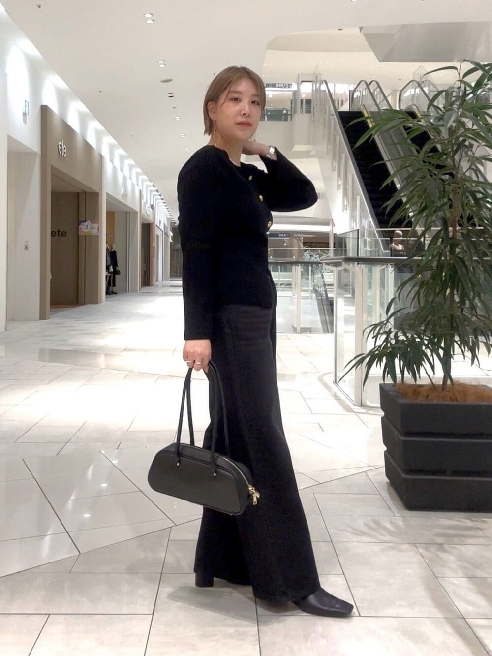 ブラック系のカーディガン/ボレロ、ブラック系のデニムパンツ、ブラック系のブーツを着用したレディースの秋コーディネートの2枚目の写真