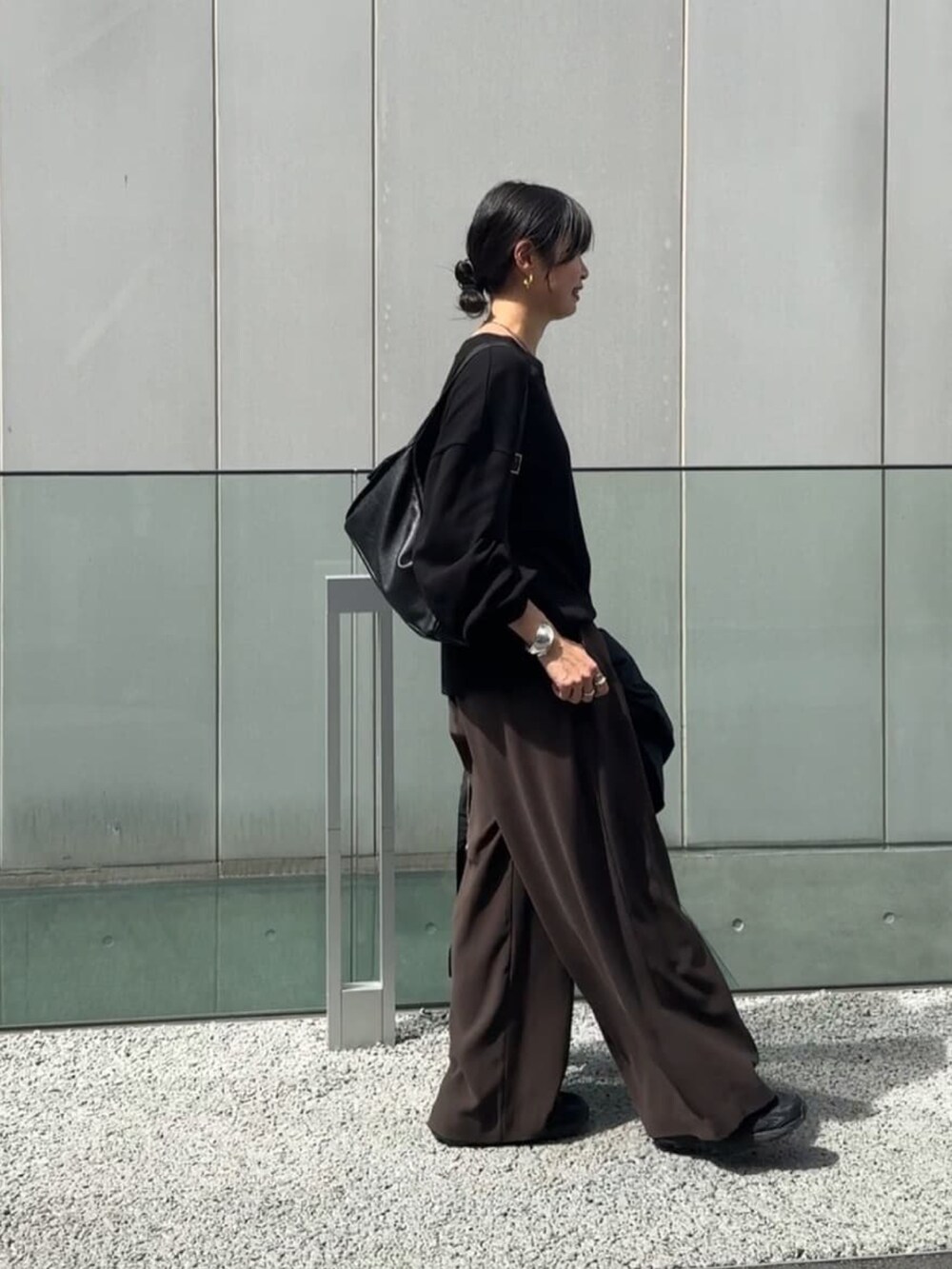 ブラック系のTシャツ/カットソー、ブラウン系のスラックスを着用したレディースの秋コーディネートの3枚目の写真