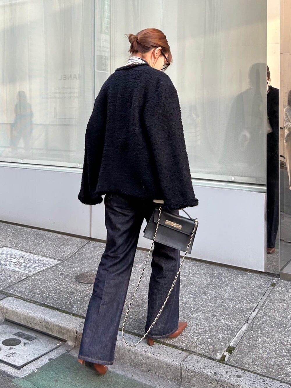 ブラック系のその他アウター、ホワイト系のニット/セーター、ブルー系のデニムパンツを着用したレディースの冬コーディネートの3枚目の写真