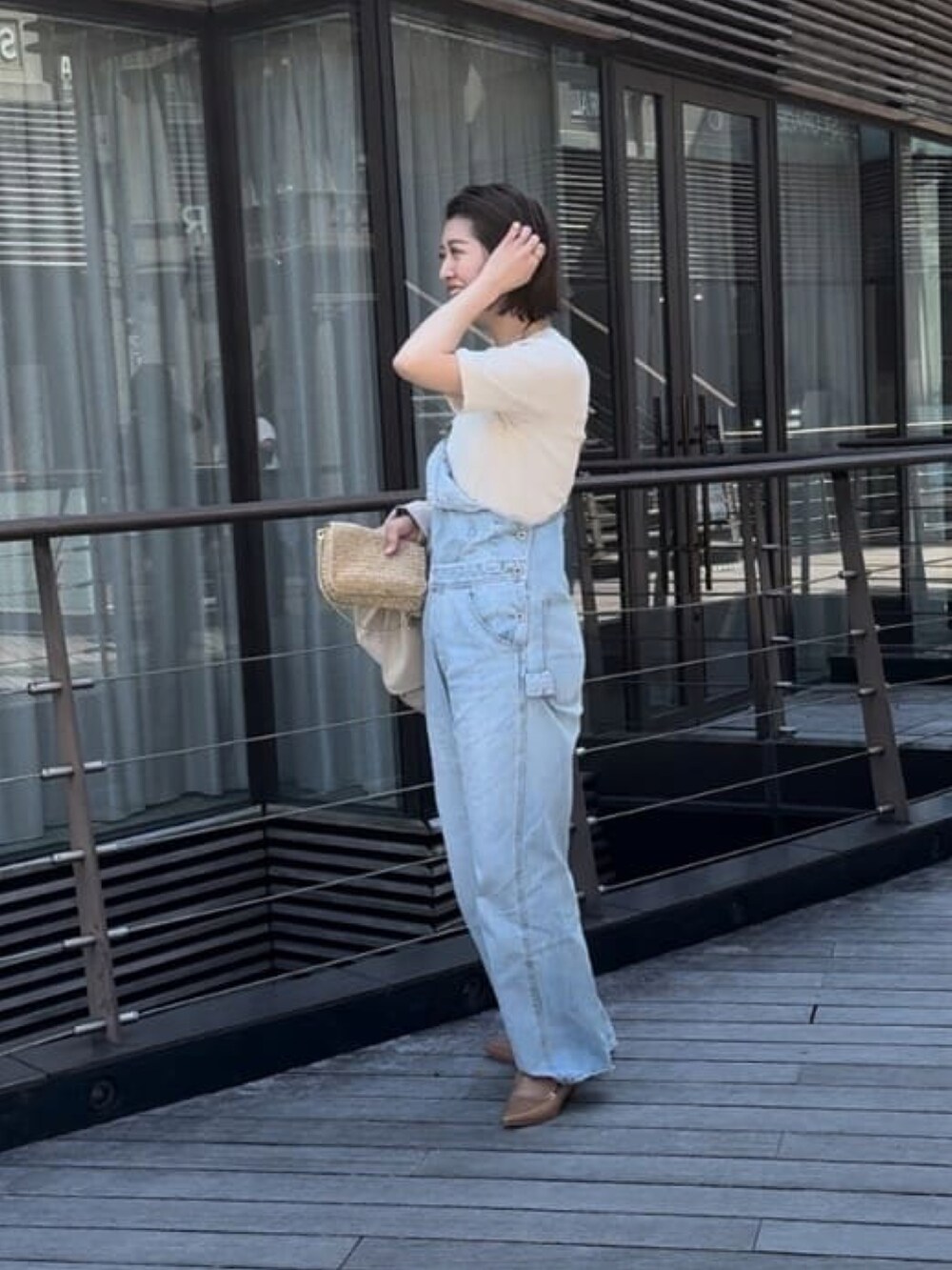 ブルー系のサロペット/オーバーオール、グレー系のTシャツ/カットソーを着用したレディースの春コーディネートの3枚目の写真