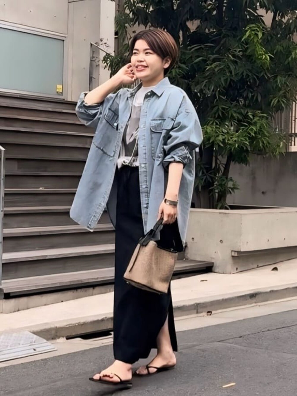 グレー系のTシャツ/カットソー、ブルー系のシャツ/ブラウス、ブラック系のスカートを着用したレディースの春コーディネートの2枚目の写真