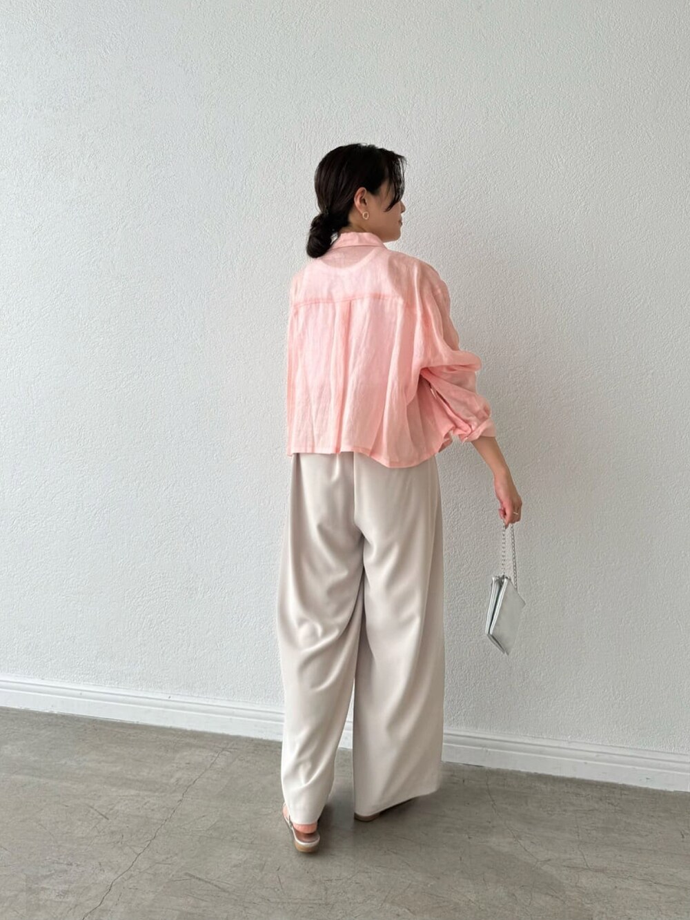 ピンク系のシャツ/ブラウス、ホワイト系のタンクトップ、グレー系のスラックスを着用したレディースの春コーディネートの3枚目の写真