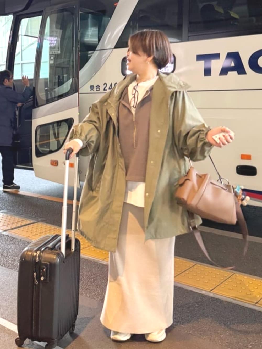 ホワイト系のTシャツ/カットソー、ホワイト系のスカート、グリーン系のその他アウターを着用したレディースの冬コーディネートの3枚目の写真