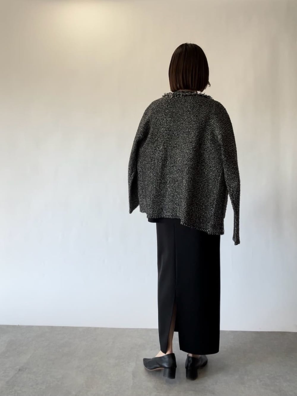 ブラック系のTシャツ/カットソー、ブラック系のカーディガン/ボレロ、ブラック系のスカートを着用したレディースの冬コーディネートの2枚目の写真