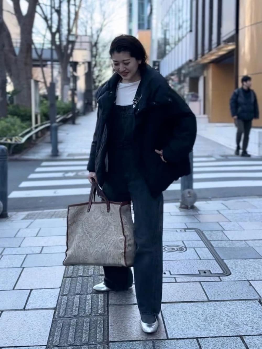 ブラック系のダウンジャケット/コート、ブラック系のサロペット/オーバーオールを着用したレディースの冬コーディネートの2枚目の写真