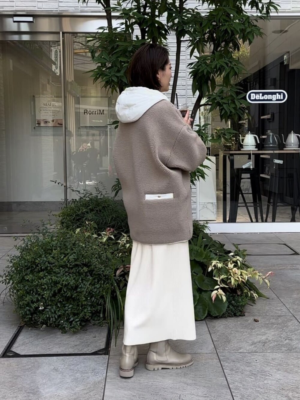 ベージュ系のその他アウター、ホワイト系のワンピース、ベージュ系のブーツを着用したレディースの冬コーディネートの3枚目の写真