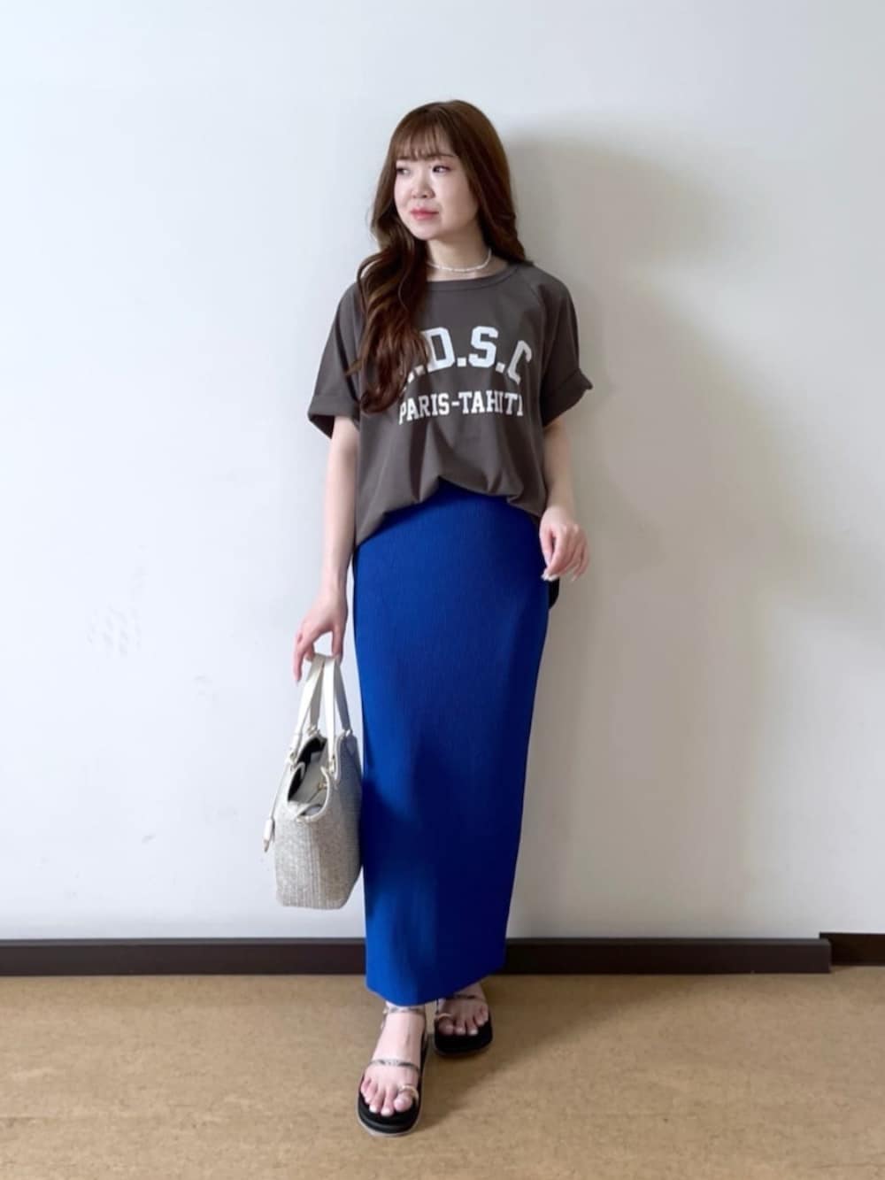 ブラウン系のTシャツ/カットソー、ホワイト系のハンドバッグ、ベージュ系のサンダルを着用したレディースの夏コーディネートの2枚目の写真