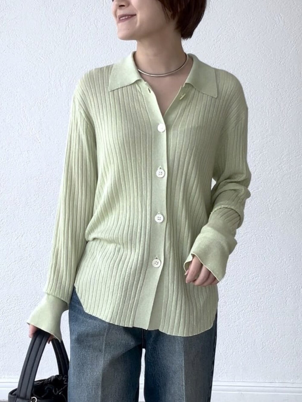 グリーン系のカーディガン/ボレロ、ブルー系のデニムパンツ、ブラック系のハンドバッグを着用したレディースの夏コーディネートの4枚目の写真