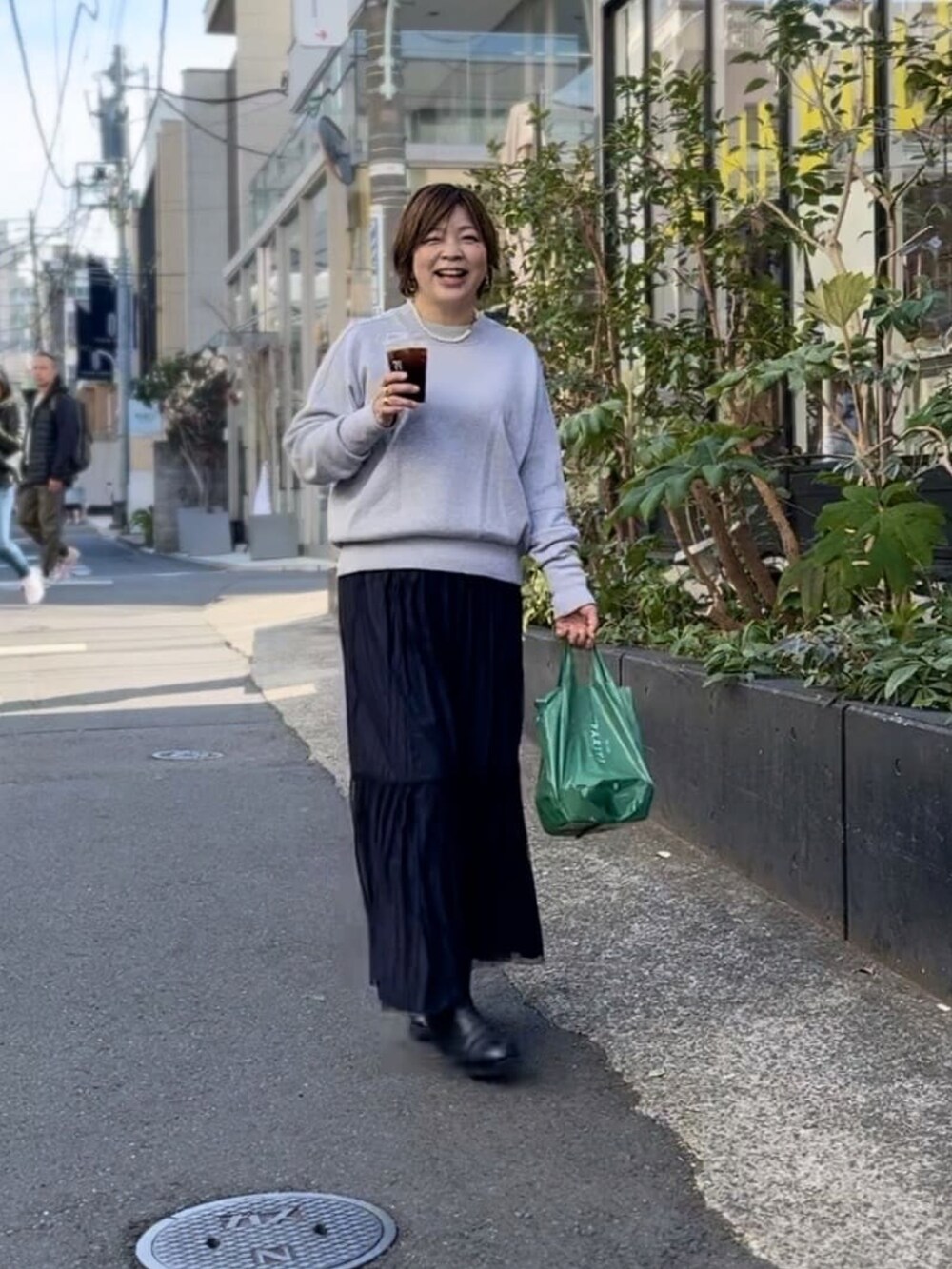 ホワイト系のニット/セーター、ブラック系のスカート、ブラック系のブーツを着用したレディースの冬コーディネートの3枚目の写真