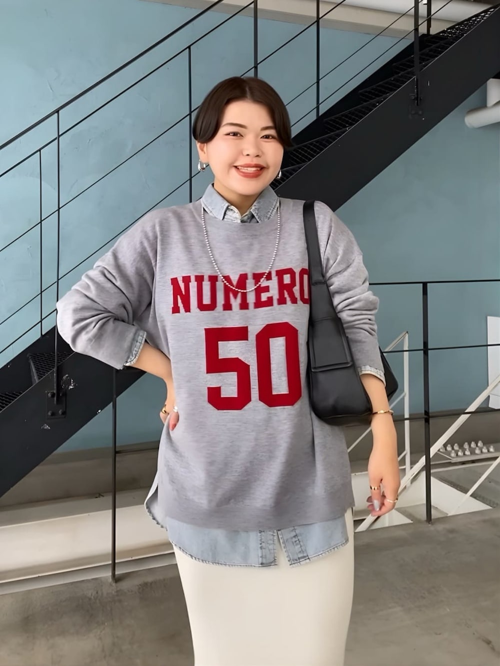 グレー系のニット/セーター、ブルー系のシャツ/ブラウス、ベージュ系のスカートを着用したレディースの秋コーディネートの3枚目の写真