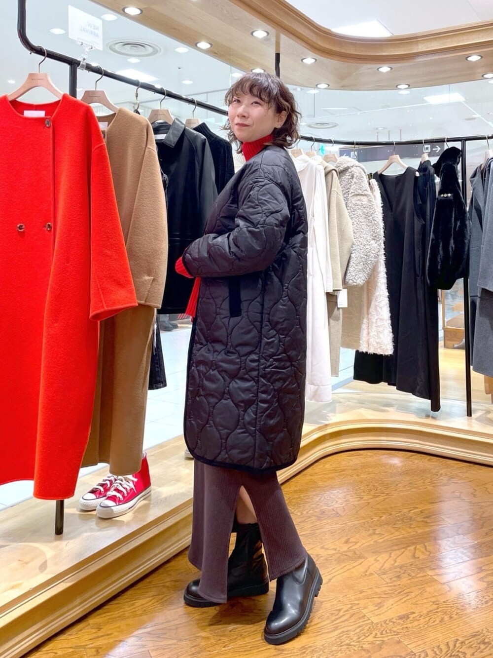 ブラック系のダウンジャケット/コート、ブラウン系のワンピースを着用したレディースの冬コーディネートの2枚目の写真