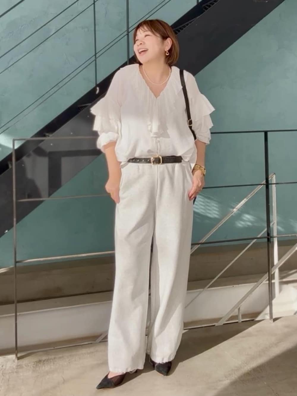 ブラック系のパンプス、グレー系のスウェットパンツ、ホワイト系のシャツ/ブラウスを着用したレディースの春コーディネートの2枚目の写真