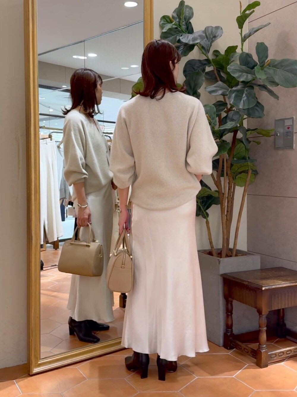 ベージュ系のボストンバッグ、ベージュ系のカーディガン/ボレロ、ベージュ系のスカートを着用したレディースの秋コーディネートの3枚目の写真