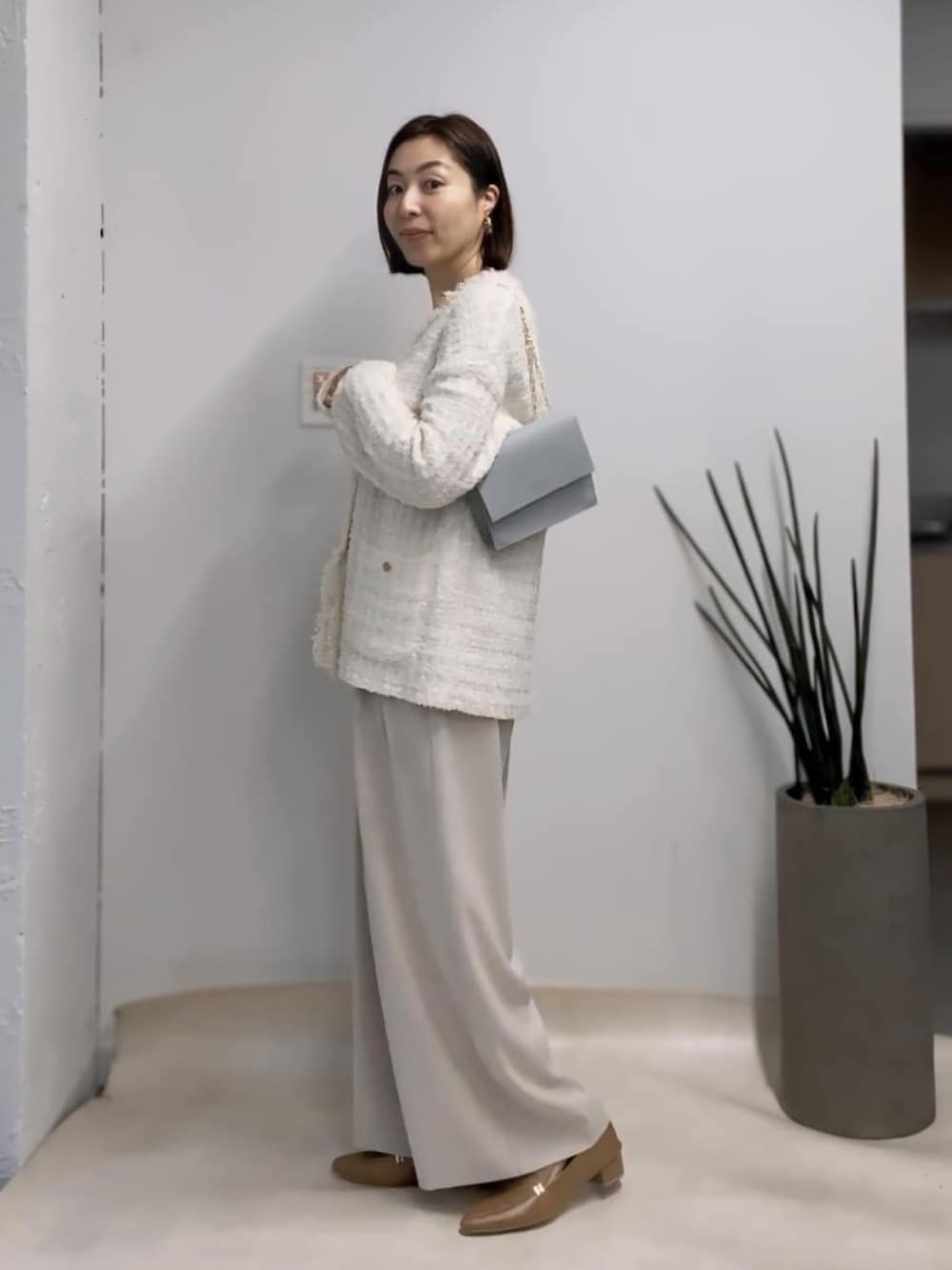 ホワイト系のカーディガン/ボレロ、グレー系のスラックス、ベージュ系のローファーを着用したレディースの冬コーディネートの2枚目の写真