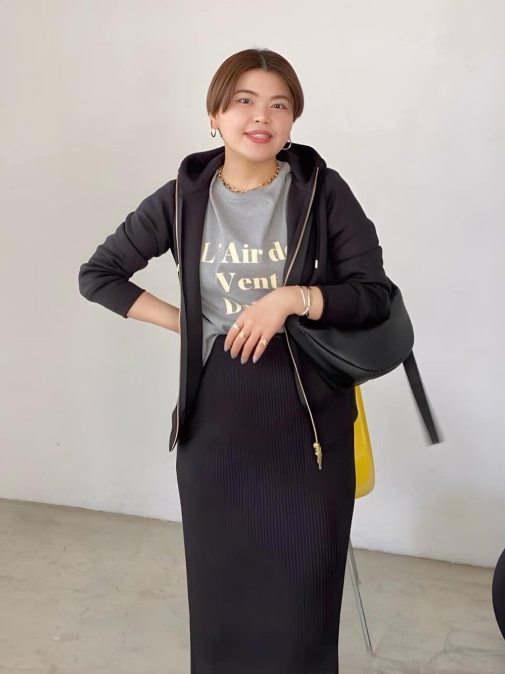 ブラック系のスカート、ブラウン系のボディバッグ/ウエストポーチ、グレー系のTシャツ/カットソーを着用したレディースの春コーディネートの3枚目の写真