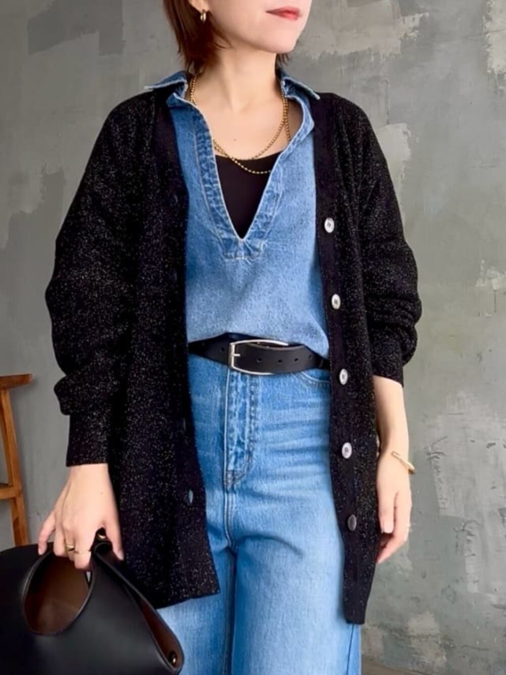 ブラック系のニット/セーター、ブルー系のシャツ/ブラウス、ブルー系のデニムパンツを着用したレディースの秋コーディネートの7枚目の写真